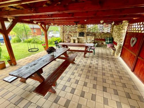 a patio with two wooden benches and a table at Ubytovanie Marta Kováčová in Bešeňová
