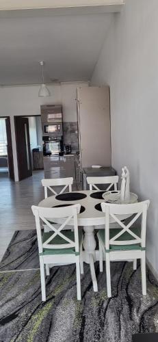 a white table and chairs in a room with a kitchen at Apartament Przejazdowa in Racibórz