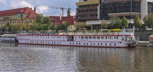 a large boat is docked on a river with buildings at River hotel KÖNIGSTEIN in Prague