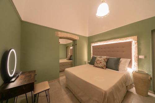 una camera da letto con un letto, una scrivania e uno specchio di Trullo Alfieri - Relax e Garden ad Alberobello