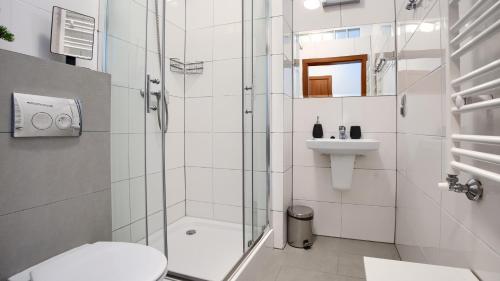 a bathroom with a shower and a toilet and a sink at Apartamenty Sun & Snow Family Dominikana Resort & SPA in Sianozety