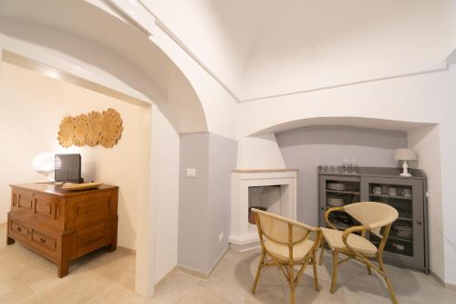 a living room with a table and chairs and a desk at Trullo Alfieri - Relax e Garden in Alberobello