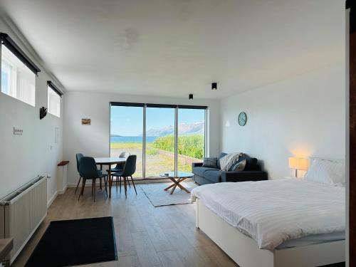 um quarto com uma cama, uma mesa e cadeiras em Waterfront Fjord House em Litli-Árskógssandur