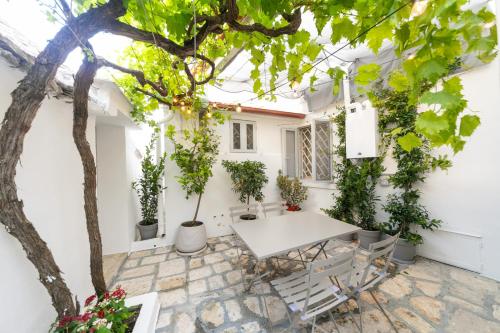 un cortile con un tavolo bianco e piante in vaso di Trullo Alfieri - Relax e Garden ad Alberobello