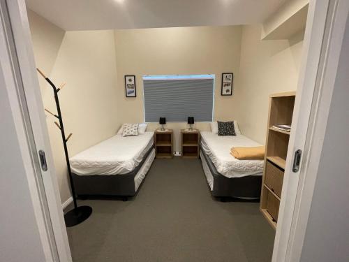 Cette petite chambre comprend 2 lits et une fenêtre. dans l'établissement Courtyard Loft 12 The Stables Perisher, à Perisher Valley