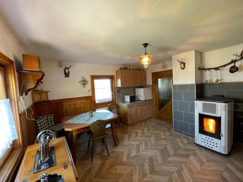 a kitchen with a table and a fireplace in it at Ferienhütte Simon Gregor in Eitweg