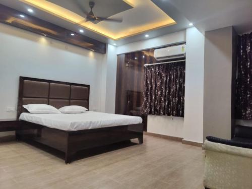 a bedroom with a bed in a room with a ceiling at Surya Niwesh 103 in Varanasi