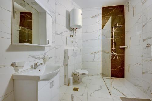 uma casa de banho com um lavatório, um WC e um chuveiro em Sea Salt Apartment em Kruče