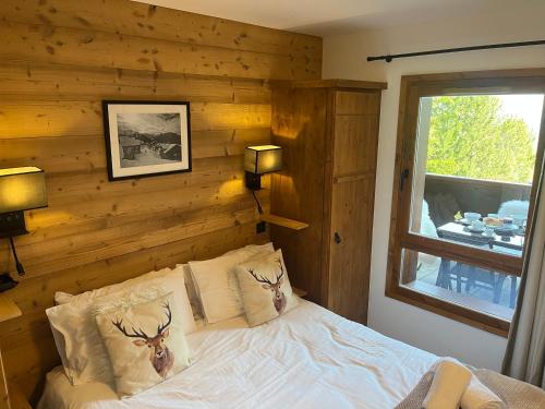 a bedroom with a bed with two deer pillows at Arc 1950 Ski in Ski out and Spa- Newly refurbished 153 Sources De Marie- 2 bedroom , 2 bathroom-Sleeps 4-6, Mont Blanc view from every window, Free WiFi in Arc 1950