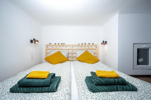1 dormitorio con 1 cama con 2 almohadas verdes y amarillas en Green Goblin Apartment with FREE PRIVATE PARKING, en Budapest