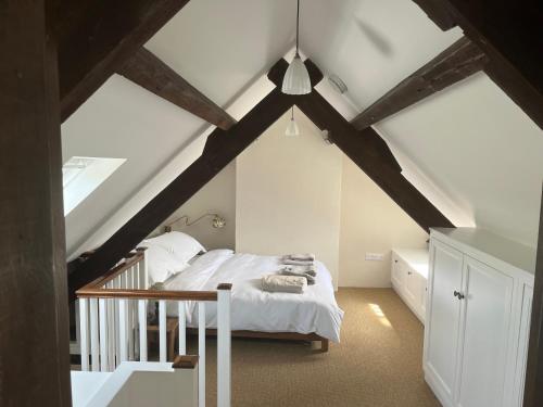 um quarto com uma cama branca num sótão em Alms Houses em Kinsale