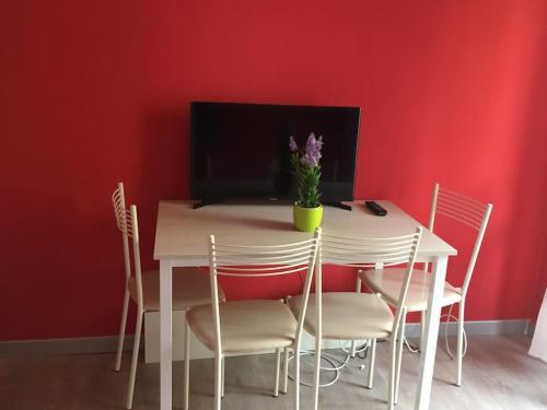 una mesa de comedor y sillas con una pared roja en Trilocale IMMinens mari en Copanello