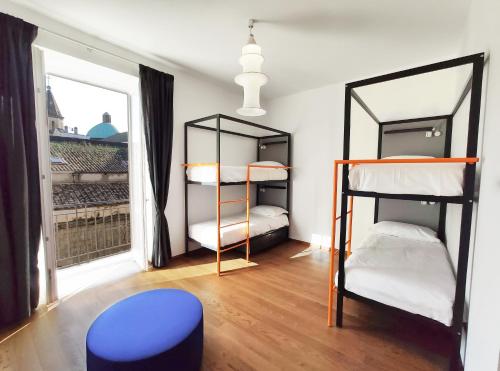 una stanza con tre letti a castello e una finestra di Tric Trac Hostel a Napoli