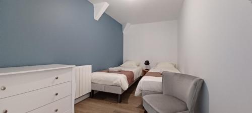 1 dormitorio pequeño con 2 camas y 1 silla en Le Logis de la Place, en Thouars