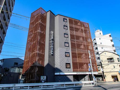 a building with a sign on the side of it at HOTEL LiVEMAX Kyoto Nijojo-kita in Kyoto