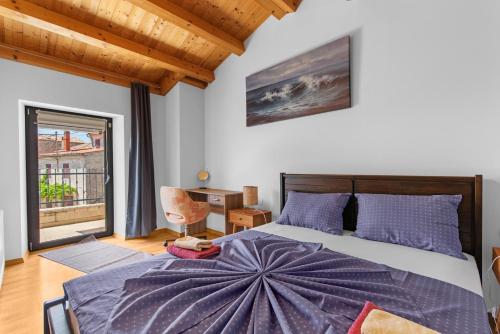 ein Schlafzimmer mit großem Bett und Fenster in der Unterkunft Villa Maria Tadini in Kaštelir