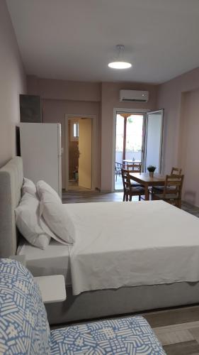 a bedroom with a large white bed and a table at Deluxe Studio Tolo in Tolo