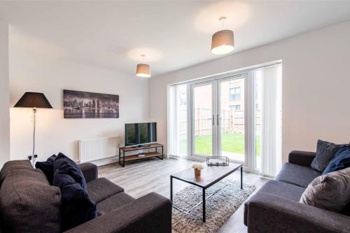 a living room with a couch and a tv at Saxelbye House - Cosy 3 Bed Home near City Centre in Derby