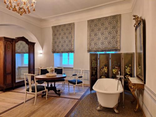 a bathroom with a tub and a table and a dining room at Stadtpalais Königssuite maximal 2 Personen und 1 Kleinkind in Bautzen