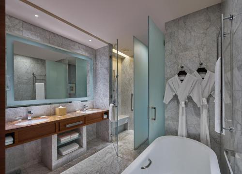 a bathroom with a tub and a sink and a shower at Grand Hyatt Manila in Manila