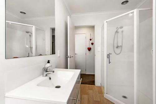 un bagno bianco con lavandino e doccia di An elegant 2-bedroom house in Hamilton central. a Hamilton