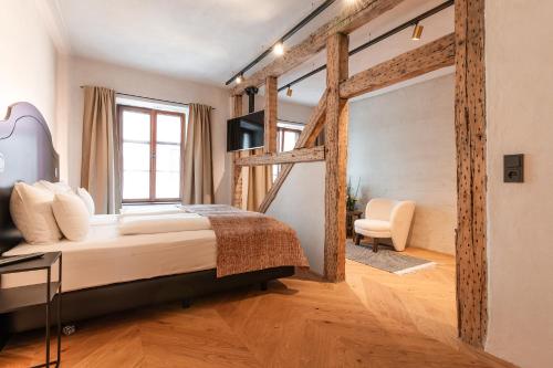 a bedroom with a bed and a large window at H5 Grauer Bär Studios & More in Innsbruck