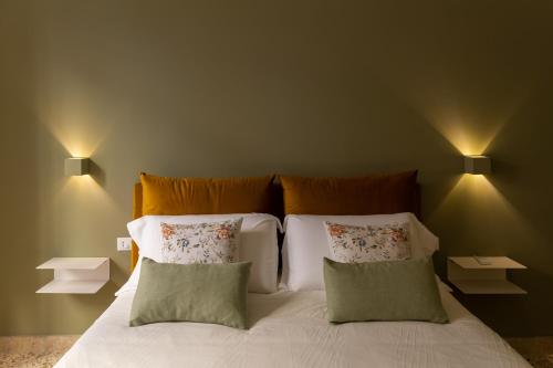 1 dormitorio con 1 cama con sábanas y almohadas blancas en Casa Franca, en Marsala
