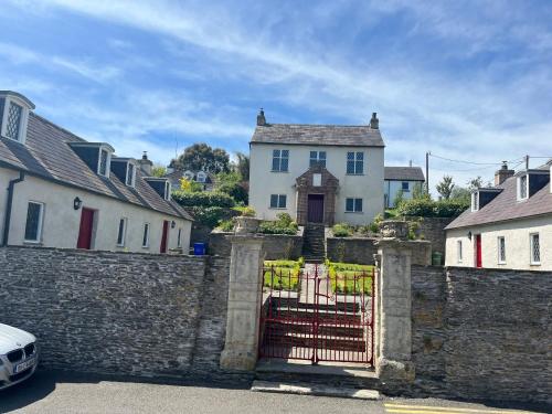 a gate in a stone wall in front of a house at Alms Houses in Kinsale
