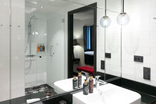a bathroom with a sink and a mirror at Hotel U14, Autograph Collection in Helsinki