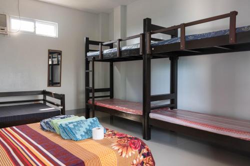 a room with three bunk beds in a house at D Guest House Ilocos in Laoag