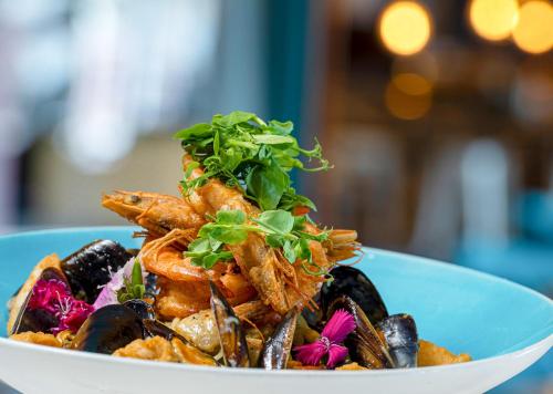 a plate of food with shrimp and mussels at Peninsula All Suite Hotel by Dream Resorts in Cape Town