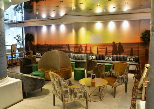 a lobby with a couch and chairs and a table at Peninsula All Suite Hotel by Dream Resorts in Cape Town
