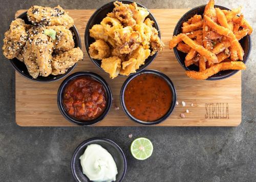 a wooden tray with different types of food on it at Peninsula All Suite Hotel by Dream Resorts in Cape Town