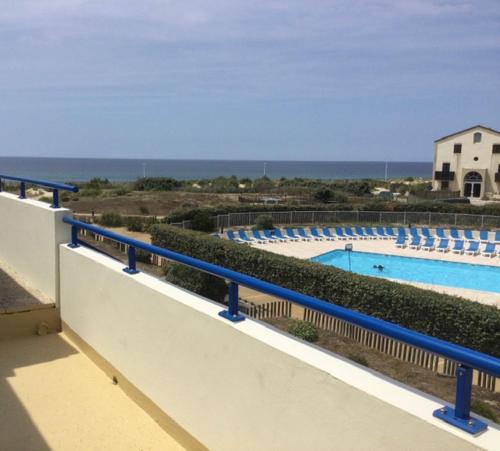 uma vista para uma piscina com um corrimão azul em SUPERBE T3 LES PIEDS DANS L'EAU, parking, piscine en été em Lacanau-Océan