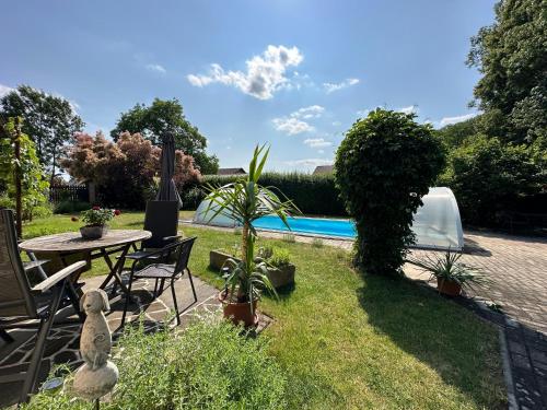 a garden with a table and chairs and a pool at Na Statku Babiččino údolí in Česká Skalice