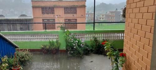 a view of a balcony with flowers in the rain at COMMUNITY HOLIDAY INN in Panauti