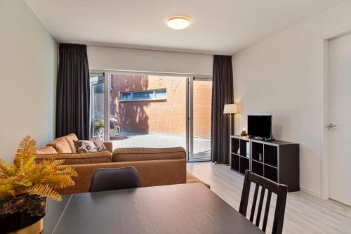 a living room with a couch and a table at Eindhoven City Suites Hertogstraat I Modern 4P in Eindhoven