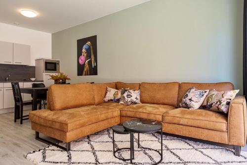 a living room with a brown couch and a table at Eindhoven City Suites Hertogstraat I Modern 4P in Eindhoven