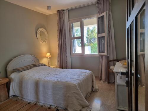 um quarto com uma cama e uma janela em EXQUISITE GOLF VILLA with Sea, 8Tee, Green Views, in Aphrodite Hills Golf Resort em Kouklia