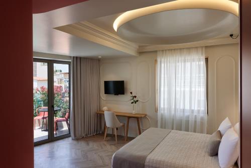 a hotel room with a bed and a table and a balcony at DWELL - Elegant City Stay in Athens