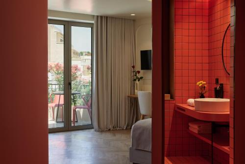 a red tiled bathroom with a sink and a balcony at DWELL - Elegant City Stay in Athens