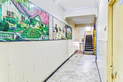 un corridoio con dipinti alle pareti di OYO Suraj Residency a Warangal