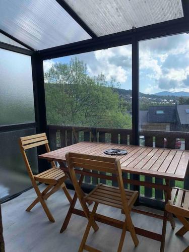 - une table et des chaises en bois sur une terrasse couverte dans l'établissement Pyrénées 2000 chalet 4 pers., à Bolquère-Pyrénées 2000