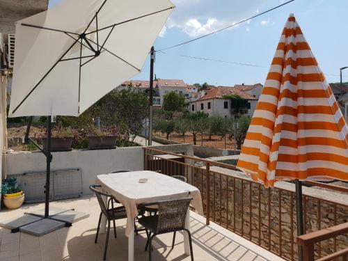 a patio with an umbrella and a table and chairs at Apartment Tereza in Sutivan