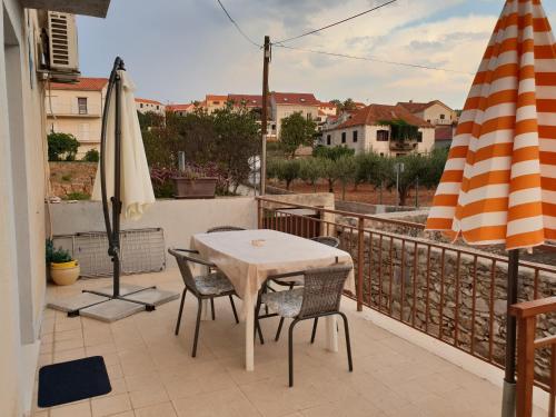 a table and chairs on a balcony with an umbrella at Apartment Tereza in Sutivan