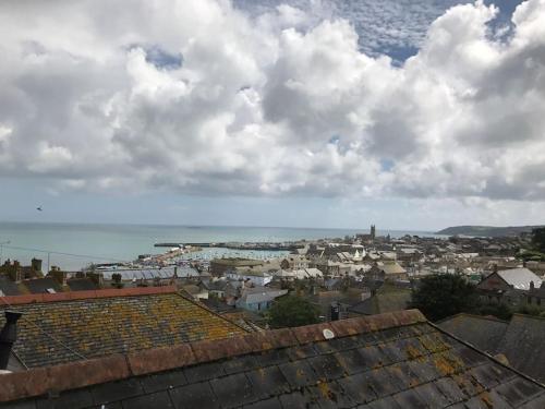 a city with houses and the ocean in the background at Modern Attic Studio Apartment with harbour views in Penzance
