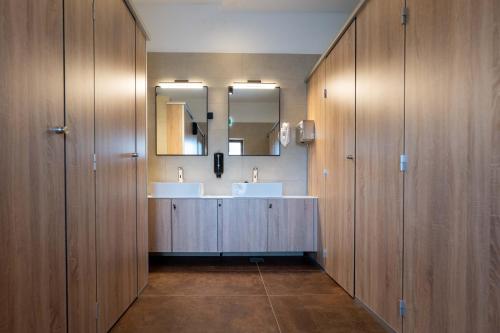 un bagno con due lavandini e un grande specchio di Dionis Zaton - Camping, Glamping, Holiday Houses & Rooms a Zaton