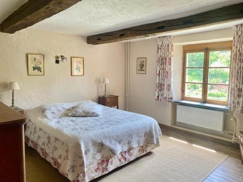 a bedroom with a bed and a window at B&B Le Moulin de Resteigne in Resteigne