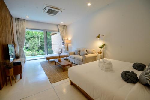 a bedroom with a bed and a living room at Proud Phu Fah Muang Chiang Mai in Chiang Mai