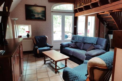a living room with a blue couch and chairs at La grange in Bio